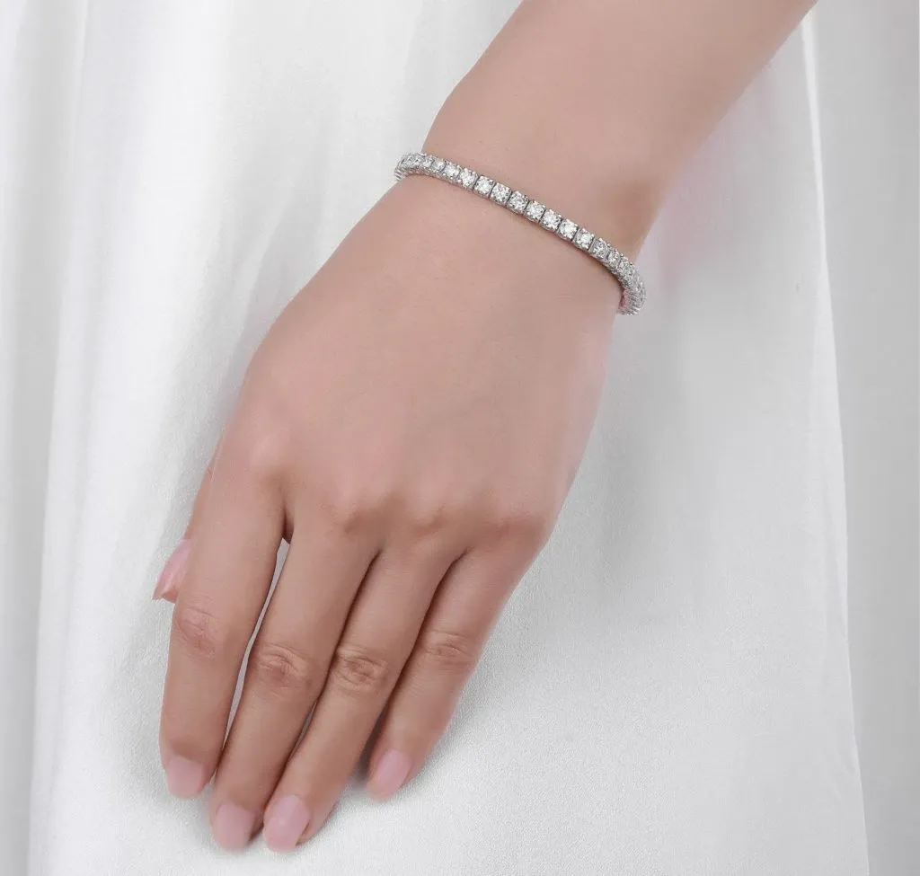 A bride elegantly wears a sparkling diamond bracelet on her wrist, showcased as part of the wedding jewelry collection by Bijouterie B. Serkos. The bracelet features a series of glittering diamonds meticulously set in a seamless band, perfect for adding a touch of sophistication to a bridal ensemble. The image captures the fine detail and craftsmanship of the jewelry, emphasizing its role in completing a graceful wedding look.