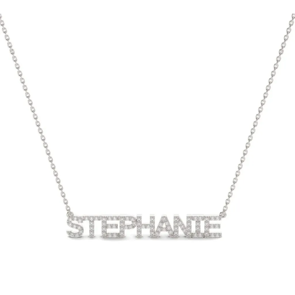 This image showcases a stunning personalized necklace designed by Bijouterie La Voûte, a vendor in the Wedding Jewelry category on Mariage Elegant, Canada. The necklace features the name 'Stephanie' beautifully crafted in elegant, sparkling silver letters, each encrusted with small, shimmering diamonds. The fine chain complements the delicate and sophisticated design, making it a perfect choice for brides seeking a unique and personalized touch to their wedding ensemble. The craftsmanship highlights Bijouterie La Voûte's dedication to quality and elegance in wedding jewelry.