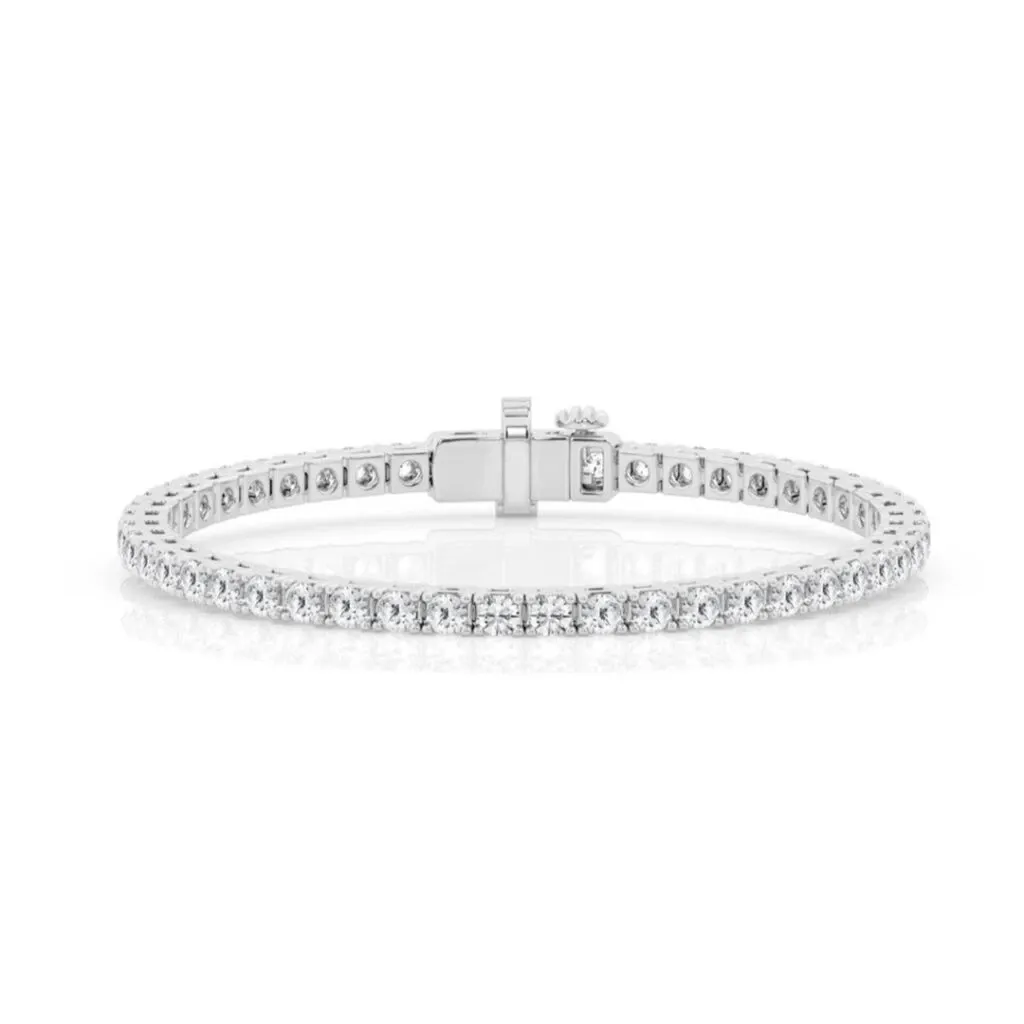 The image features a stunning diamond tennis bracelet from Bijouterie La Voûte, categorized under Wedding Jewelry. The bracelet showcases a series of perfectly aligned, sparkling round diamonds set in a sleek, polished white gold band, exuding elegance and sophistication. This exquisite piece draws attention with its timeless design, making it an ideal accessory for brides looking to add a touch of glamour to their wedding attire.