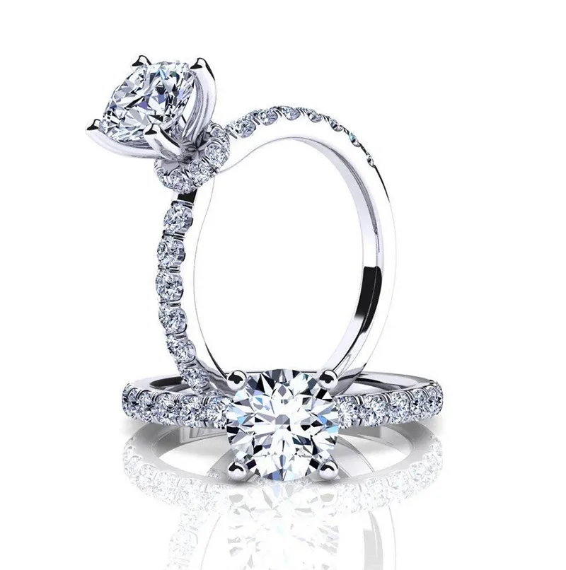Eternal Diamonds offers exquisite wedding jewelry that embodies elegance and sophistication. The image showcases two stunning diamond rings designed for weddings. The first ring features a round-cut diamond set in a classic solitaire style with a sparkling, diamond-encrusted band. The second ring also displays a round-cut diamond, elegantly mounted in a four-prong setting, with diamonds adorning the band. Ideal for couples seeking timeless and luxurious pieces for their wedding, these rings exemplify the artistry and craftsmanship of Eternal Diamonds, a premier vendor in Canada.