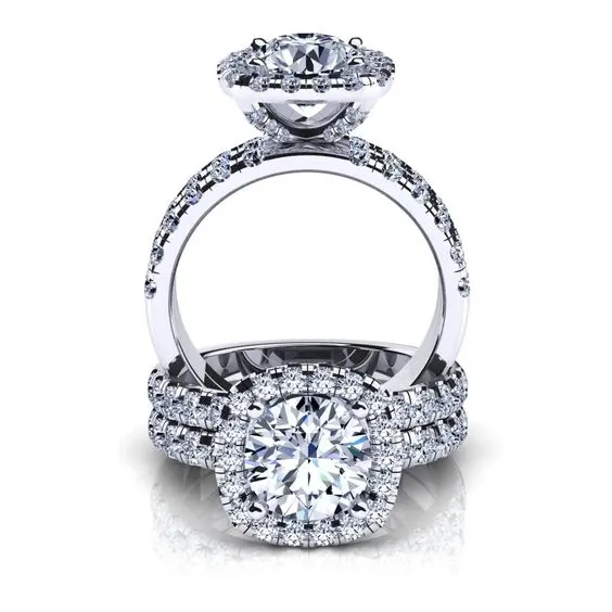 This image showcases a stunning wedding jewelry set by Eternal Diamonds, displayed under the wedding category on Mariage Elegant, Canada. The set features a beautifully designed engagement ring and a matching wedding band, crafted with exquisite attention to detail. Both rings are adorned with sparkling diamonds that enhance their elegance. The engagement ring prominently displays a brilliant round-cut center diamond, surrounded by a halo of smaller diamonds, adding to its luxurious appeal. The wedding band complements it perfectly, with a continuous row of dazzling diamonds that reflect timeless sophistication and style, ideal for couples seeking elegant and radiant pieces for their special day.