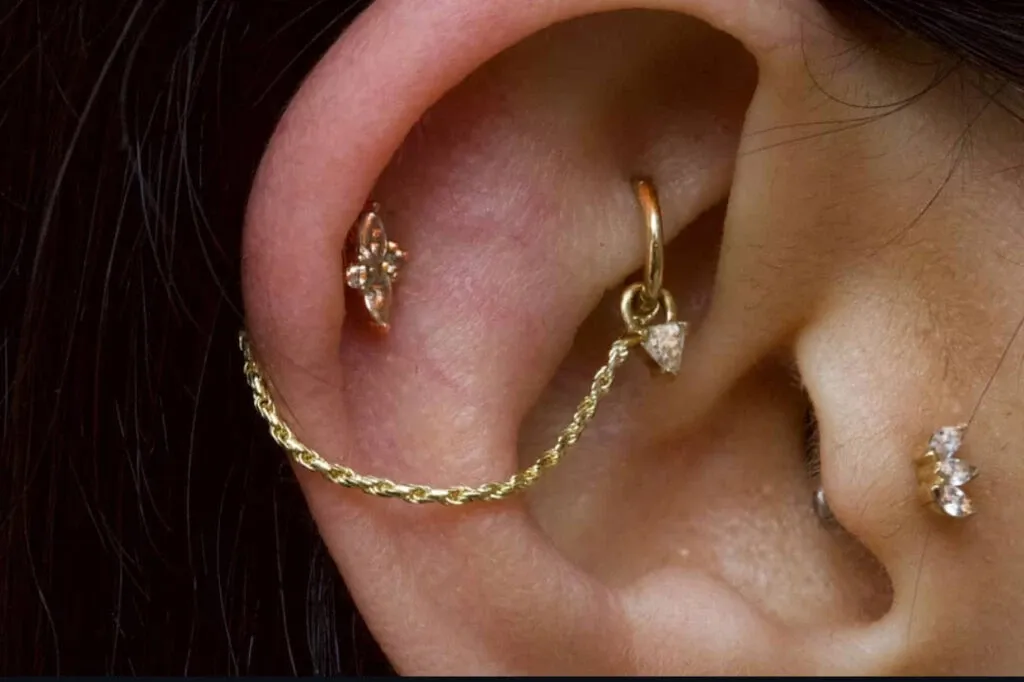 Boucles d’oreilles élégantes en or avec un design en chaîne, ornées de petits diamants sur un lobe d’oreille. Cette image met en valeur l’art raffiné et la qualité des accessoires offerts par le fournisseur Paradise Montreal dans la catégorie Beauté pour le mariage, illustrant des options sophistiquées pour les mariées cherchant à ajouter une touche de glamour à leurs tenues de mariage.