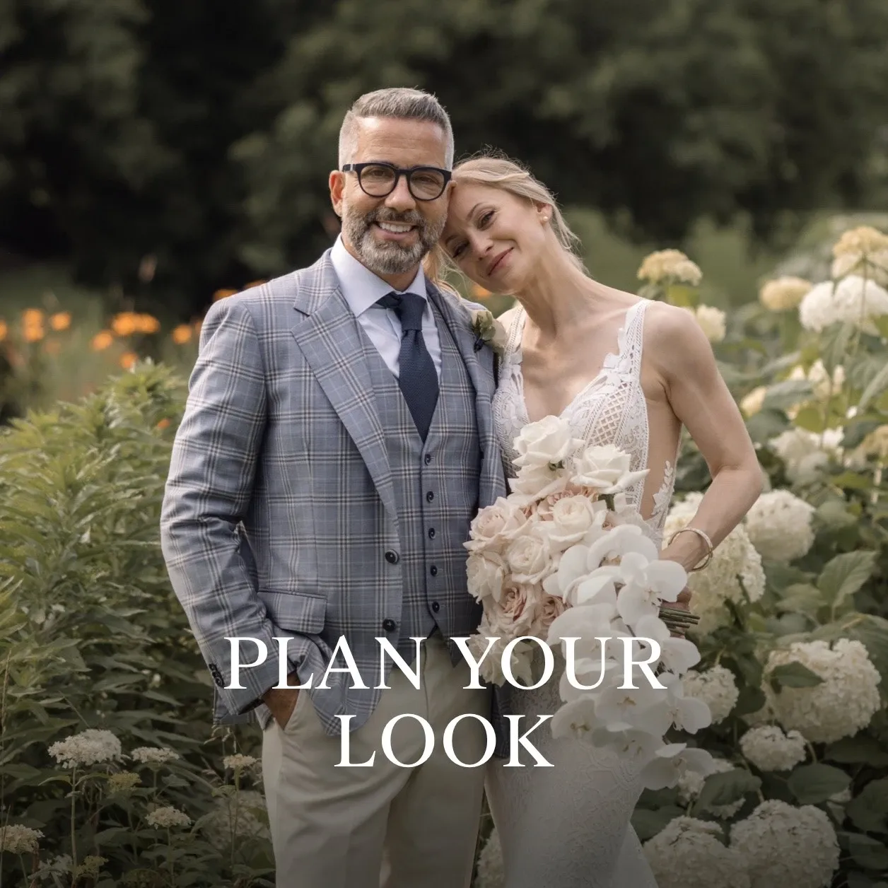 A groom wearing a stylish checkered tuxedo by Surmesur, a vendor specializing in wedding tuxedos, stands confidently in a lush garden setting. His outfit includes a sleek blue and gray plaid jacket paired with a matching vest and a light blue shirt, complemented by a navy tie. Beside him, a bride in an elegant lace wedding dress with a detailed bouquet leans affectionately on his shoulder. The setting, filled with greenery and blooming hydrangeas, captures a romantic outdoor wedding vibe. The image is part of Mariage Elegant's Canada wedding planning and vendor listing, featuring the message 'Plan Your Look' to inspire couples looking for refined bridal fashion.