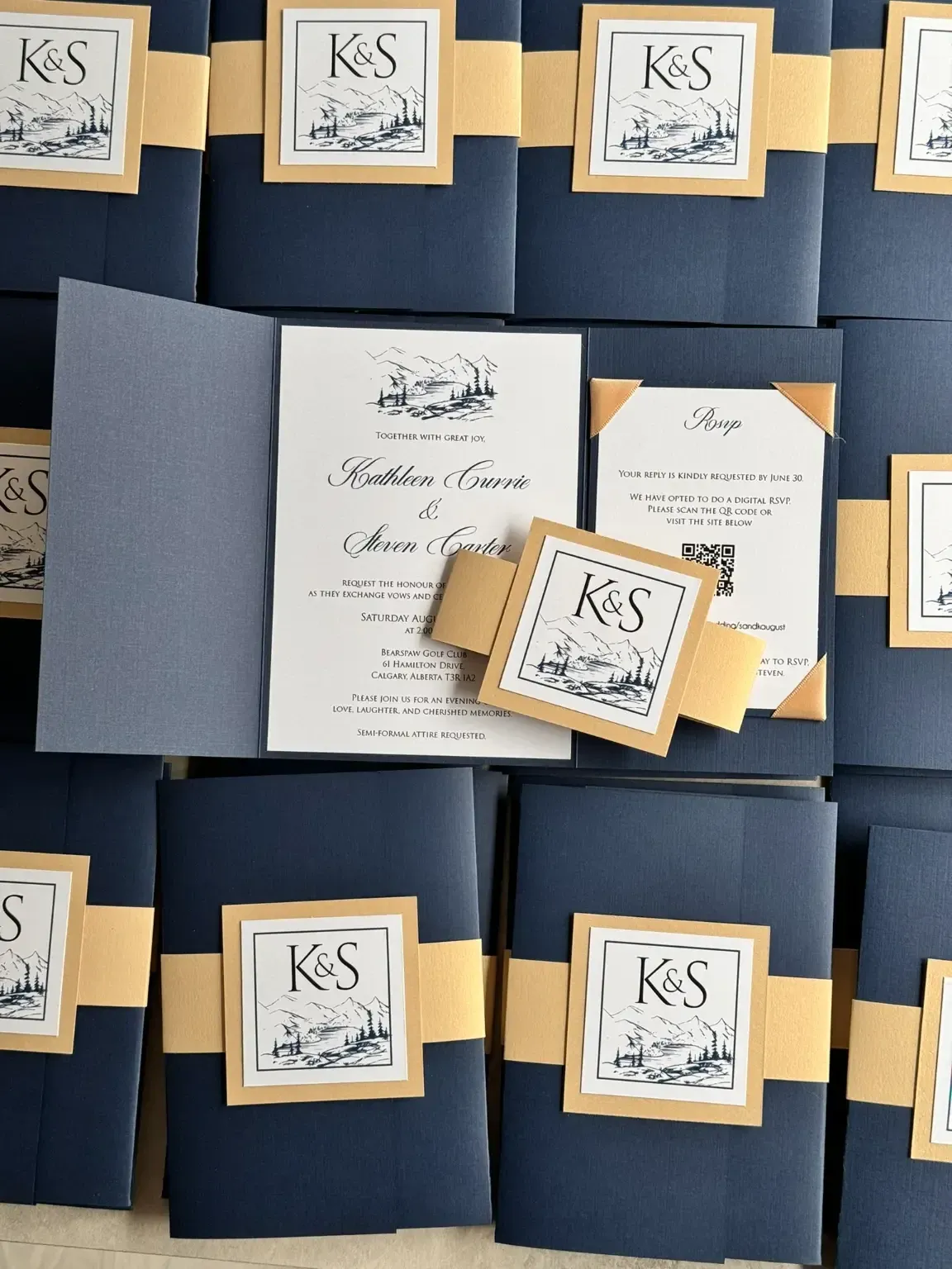 L'image présente une collection d'invitations de mariage créées par le studio Photogenia Design Studio, dans la catégorie Invitations de mariage. Les invitations sont élégamment conçues avec un motif bleu marine et doré. Au centre, l'une des invitations est ouverte, montrant un texte formel imprimé en noir sur fond blanc. Chaque invitation est ornée d'un monogramme 'K&S' dans un carré décoratif. À côté, une petite carte assortie est glissée sous une bande dorée, ajoutant une touche de sophistication. L'ensemble reflète un style raffiné et personnalisé, idéal pour un mariage chic au Canada.