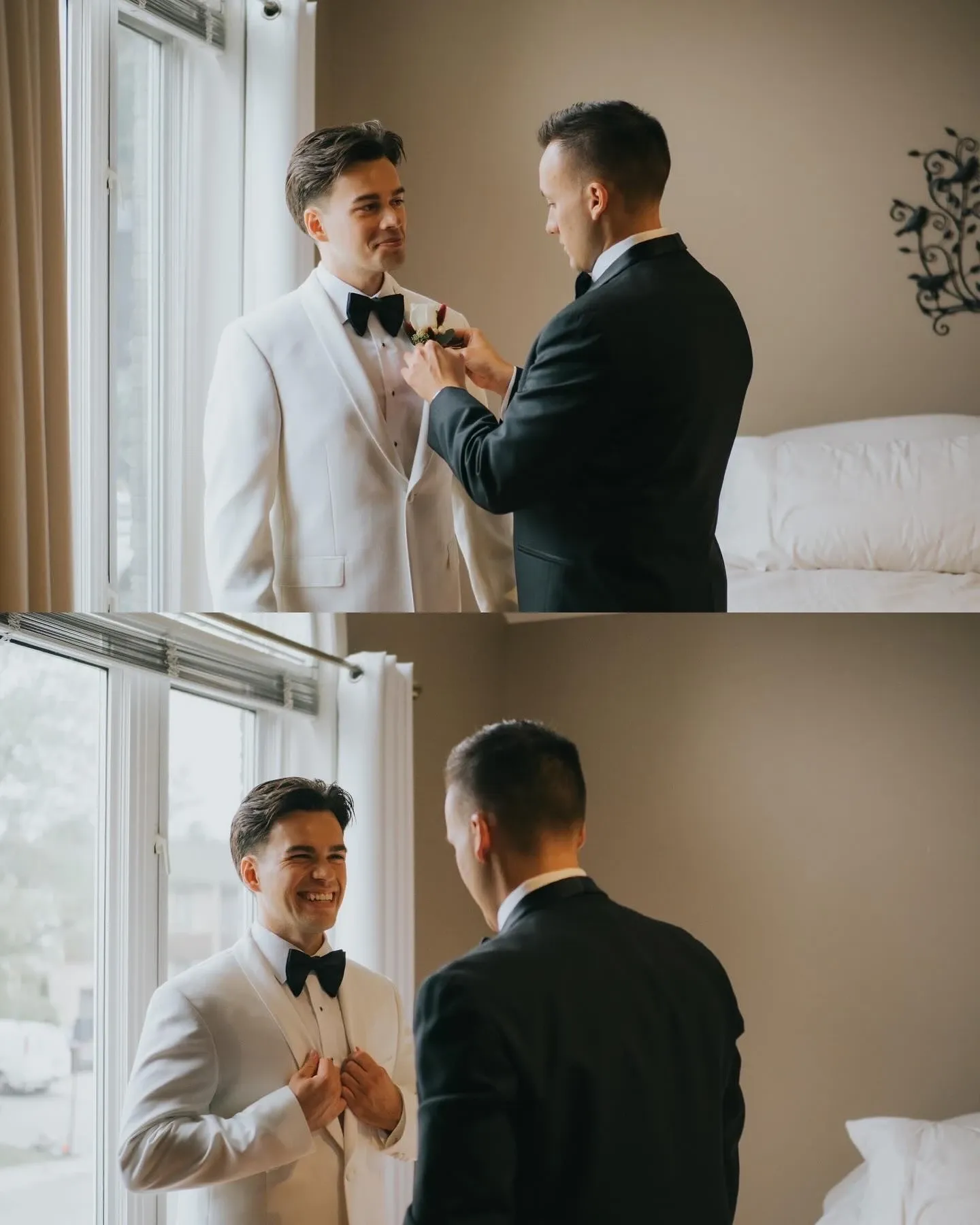 The image shows two men in a warmly lit room preparing for a wedding. The man on the left is dressed in a white tuxedo jacket and black bow tie, while the man on the right, in a traditional black suit, assists him with a boutonniere. They stand near a large window that lets in natural light, illuminating a comfortable, stylish interior. This serene wedding preparation moment showcases the work of Muriel Oe Photo, highlighting the Wedding Photography category for Mariage Elegant in Canada.