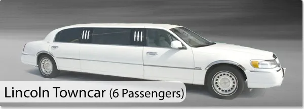 This image shows a sleek, white Lincoln Towncar limousine operated by CM Limo, categorized under wedding limousine services. The vehicle, designed to accommodate six passengers, is ideal for wedding ceremonies due to its elegant and spacious design. The limo is depicted on a smooth road, highlighting its readiness for transporting a bridal party or newlyweds in style and comfort.