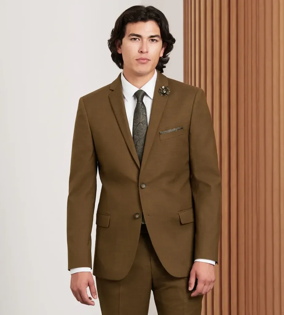 The image features a model showcasing a sleek, tailored brown tuxedo by Tip Top, a vendor listed in the Wedding Tuxedo category on Mariage Elegant, Canada. The ensemble includes a neatly tied black floral tie, a white dress shirt, and a coordinated pocket square, presenting an elegant choice for grooms seeking a classic yet contemporary look for their wedding day. The background features neutral-toned vertical panels, adding a sophisticated touch to the presentation.
