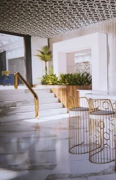 The image showcases an elegant, modern interior of the Plaza Le Rizz, a premier wedding venue in Canada. The venue features a spacious marble floor with intricate golden accents on the railings and furniture, reflecting a luxurious atmosphere ideal for weddings. A set of stairs with a golden handrail leads to an elevated area adorned with lush green plants, adding a touch of nature to the sophisticated setting. The stylish ceiling pattern complements the overall contemporary design, making it a desirable location for hosting wedding ceremonies and receptions.