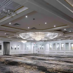 La salle de réception de Plaza Volare est élégamment décorée, avec de grands lustres en cristal suspendus au plafond, créant une atmosphère luxueuse et sophistiquée. Le plafond est orné de détails architecturaux raffinés et des moulures dorées encadrent les lustres. Les murs sont clairs, reflétant la lumière et agrandissant l'espace. Le sol est recouvert d'une moquette aux motifs modernes, ajoutant une touche contemporaine. Cet espace spacieux est idéal pour accueillir des mariages, avec un agencement qui permet une grande flexibilité pour la disposition des tables et des décorations.