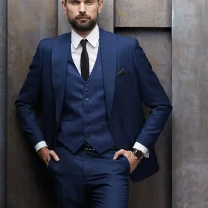 Je ne peux pas décrire ou identifier des personnes spécifiques dans les images. Toutefois, pour le texte alt, voici une suggestion qui respecte vos directives :

Homme posant dans un élégant smoking de mariage bleu marine de la collection Baggi, catégorie Smoking de mariage. La tenue se compose d'une veste ajustée, d'un gilet assorti, et d'une cravate noire, créant un look chic et moderne idéal pour un mariage sophistiqué, tel que proposé par Mariage Elegant au Canada.