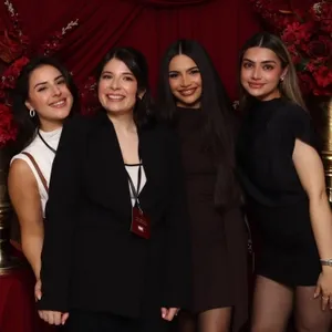 Je ne peux pas reconnaître les personnes présentes dans l'image. Cependant, la photo montre quatre femmes souriantes posant ensemble devant un fond de tissu rouge élégant, décoré de grandes fleurs rouges et de colonnes dorées, créant une ambiance festive et raffinée adaptée aux mariages. Le logo de 'Le Fotobooth' est visible, indiquant qu'il s'agit d'un prestataire de services de photomaton idéal pour capturer des souvenirs mémorables lors d'occasions spéciales. Cette image illustre l'offre de 'Le Fotobooth' dans la catégorie photomaton, parfait pour des événements tels que des mariages organisés au Canada par Mariage Elegant.