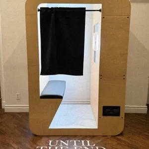 Le Fotobooth, un prestataire de la catégorie photo booth, propose ici une cabine photo moderne et élégante. La cabine, aux lignes épurées, est conçue en bois clair avec un intérieur accueillant et intime. Un rideau noir offre une touche de confidentialité, idéal pour capturer des moments spéciaux lors d'un mariage. Le sol en bois sombre contraste avec les murs clairs, et l'inscription 'UNTIL THE END OF TIME' renforce une thématique romantique, parfaite pour un événement de mariage élégant.
