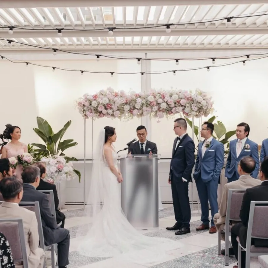 Dans cette image de la catégorie animation de Mariage Elegant, on voit la cérémonie de mariage se dérouler dans une salle lumineuse et contemporaine. L