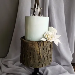 Cet élégant gâteau de mariage, signé Patisserie Artisanale Kalina, présente une conception artistique bicolore. Le gâteau est composé de deux niveaux distincts. Le niveau supérieur arbore une teinte pastel douce, tandis que le niveau inférieur imite fidèlement l'apparence d'un tronc d'arbre avec une texture boisée. En guise de décoration, une magnifique rose blanche en sucre est délicatement posée sur le côté, ajoutant une touche de romantisme. Ce gâteau de mariage constitue un choix parfait pour un mariage au thème naturel ou rustique et met en valeur le talent artisanal de Patisserie Artisanale Kalina dans la catégorie des gâteaux de mariage.