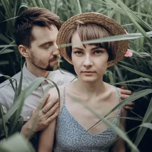 stylish rustic bride and groom embracing in windy high reed