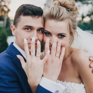 just married stylish happy bride and groom showing hands with wedding rings